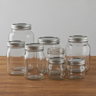 Assortment of glass canning jars on a rustic wooden table
