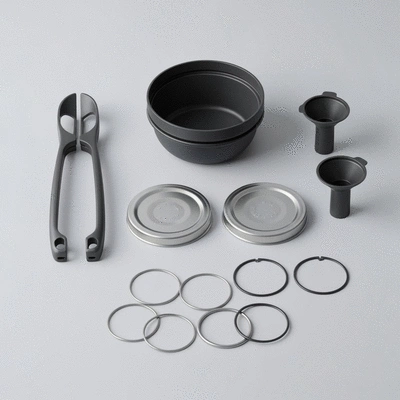 Arrangement of essential canning tools including jar lifters, funnels, lids, and rings on a clean background